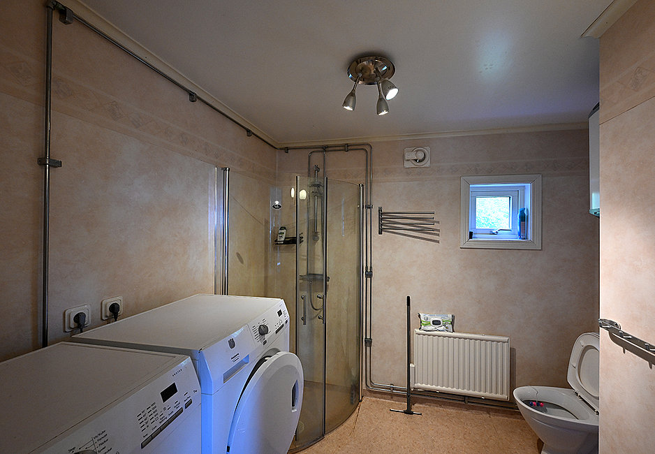 Das große Bad des Hauses Gårdstugan mit Waschmaschine und Trockner.