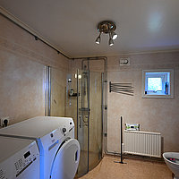 Das große Bad des Hauses Gårdstugan mit Waschmaschine und Trockner.