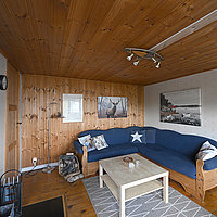 Gemütliches Wohnzimmer mit Sofa, Kaminofen und TV.