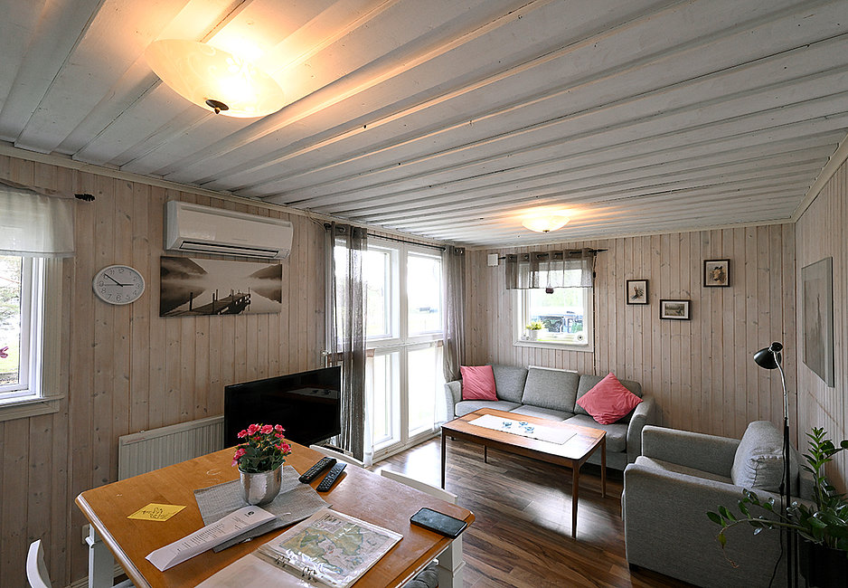 Das Wohnzimmer des Ferienhauses Gårdstugam ist gemütlich eingerichtet.