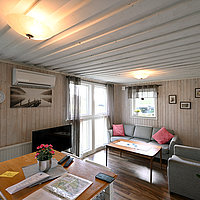 Das Wohnzimmer des Ferienhauses Gårdstugam ist gemütlich eingerichtet.