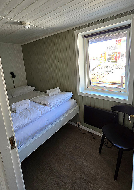 Schlazimmer mit Doppelbett in der Ferienwohnung Olufbua in der Hemmingodden Fishing Lodge in Ballstad auf den Lofoten.