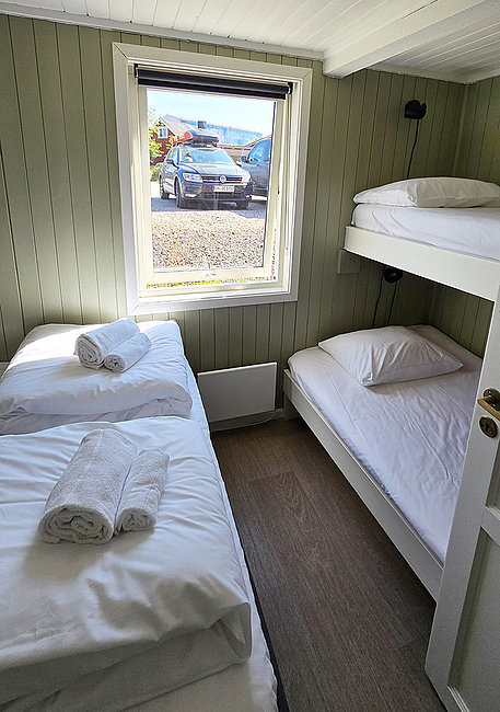Schlazimmer mit Etagenbett plus Doppelbett in der Ferienwohnung Olufbua in der Hemmingodden Fishing Lodge in Ballstad auf den Lofoten.