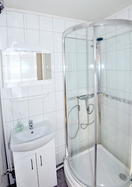 Das gekachelte Hauptbadezimmer mit Dusche und WC.