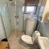 Blick ins Badezimmer von Haus 6 mit Dusche und WC.