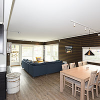Großes Wohnzimmer in Egnerbua mit Esstisch und Küchenzeile.