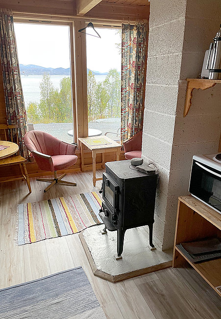 Gemütlicher Wohnraum mit Kaminofen und traumhafter Aussicht.