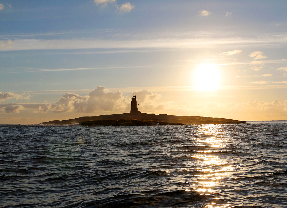 Ein Leuchtturm steht auf einer kleinen Insel in Flatanger.