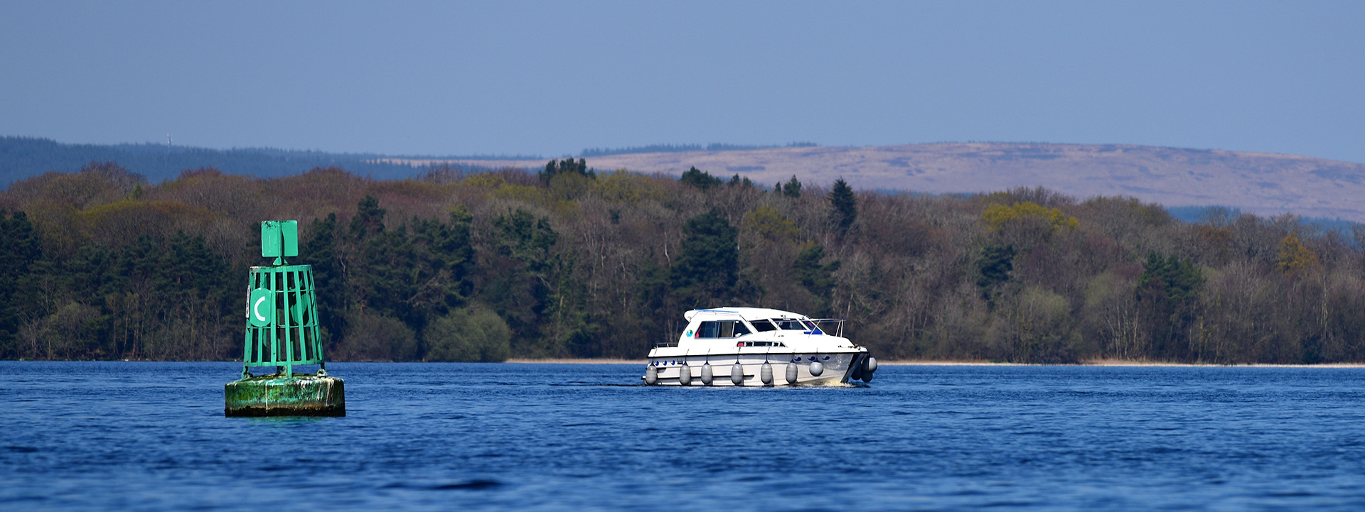Ein Hausboot fährt über einen irischen See.